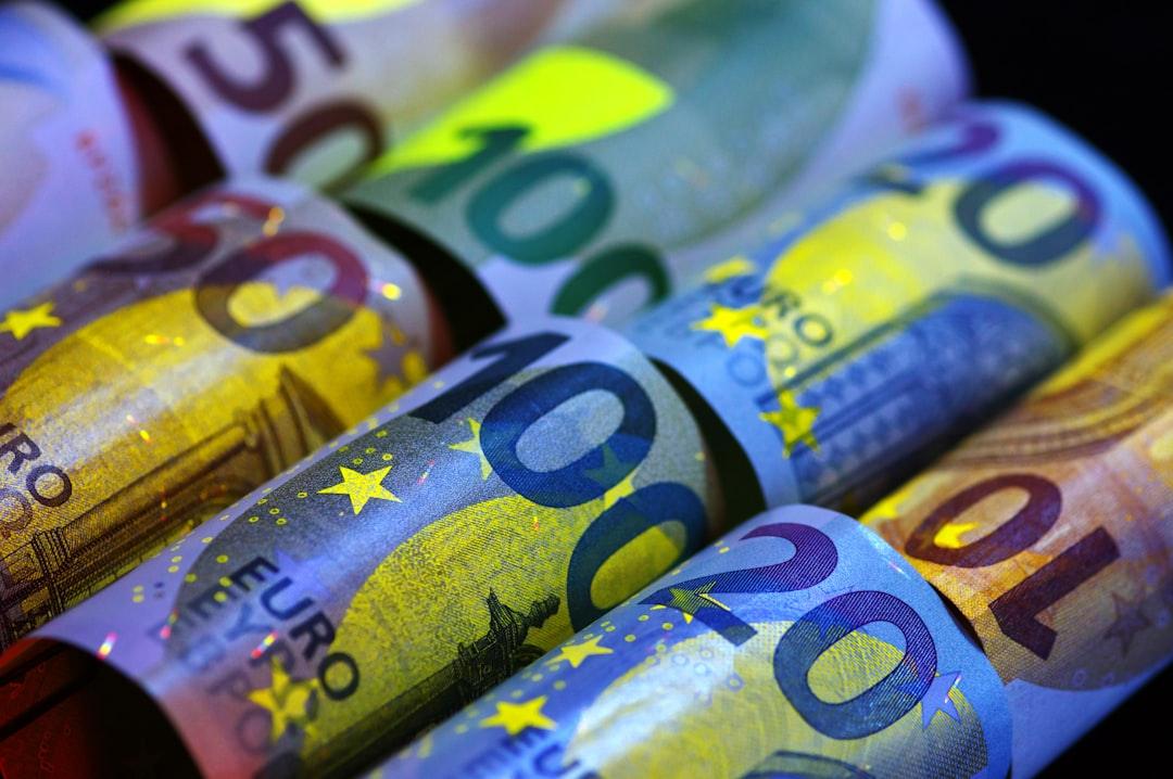 Rolled banknotes illuminated under ultraviolet light revealing covert security features for authentication