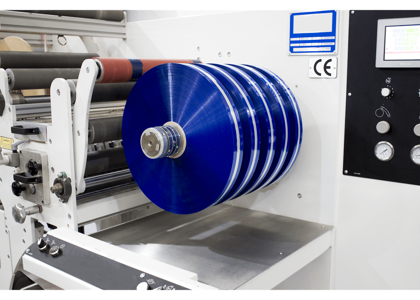 Blue tamper-evident bag tape being processed on manufacturing equipment