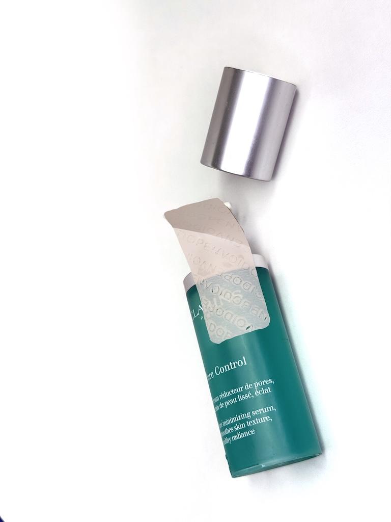 Aqua cosmetics bottle with open lid showing tamper-evident cap seal for brand protection