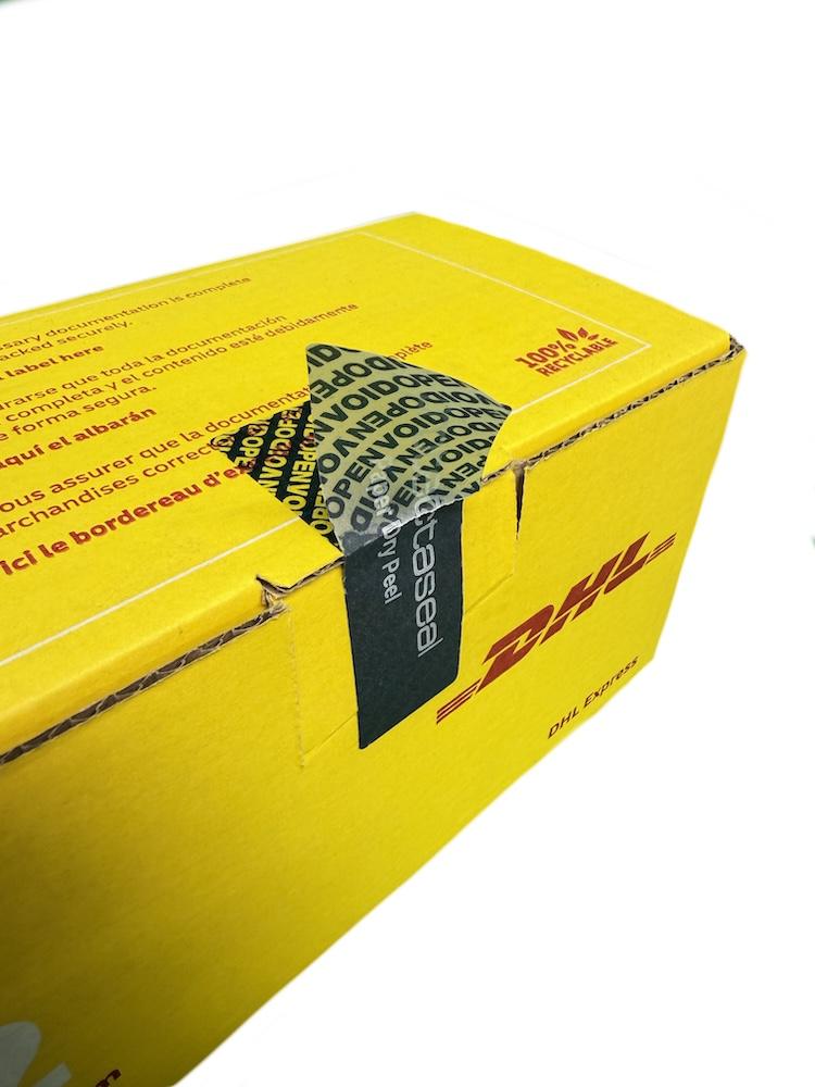 Tamper-evident security label applied to a DHL shipping box