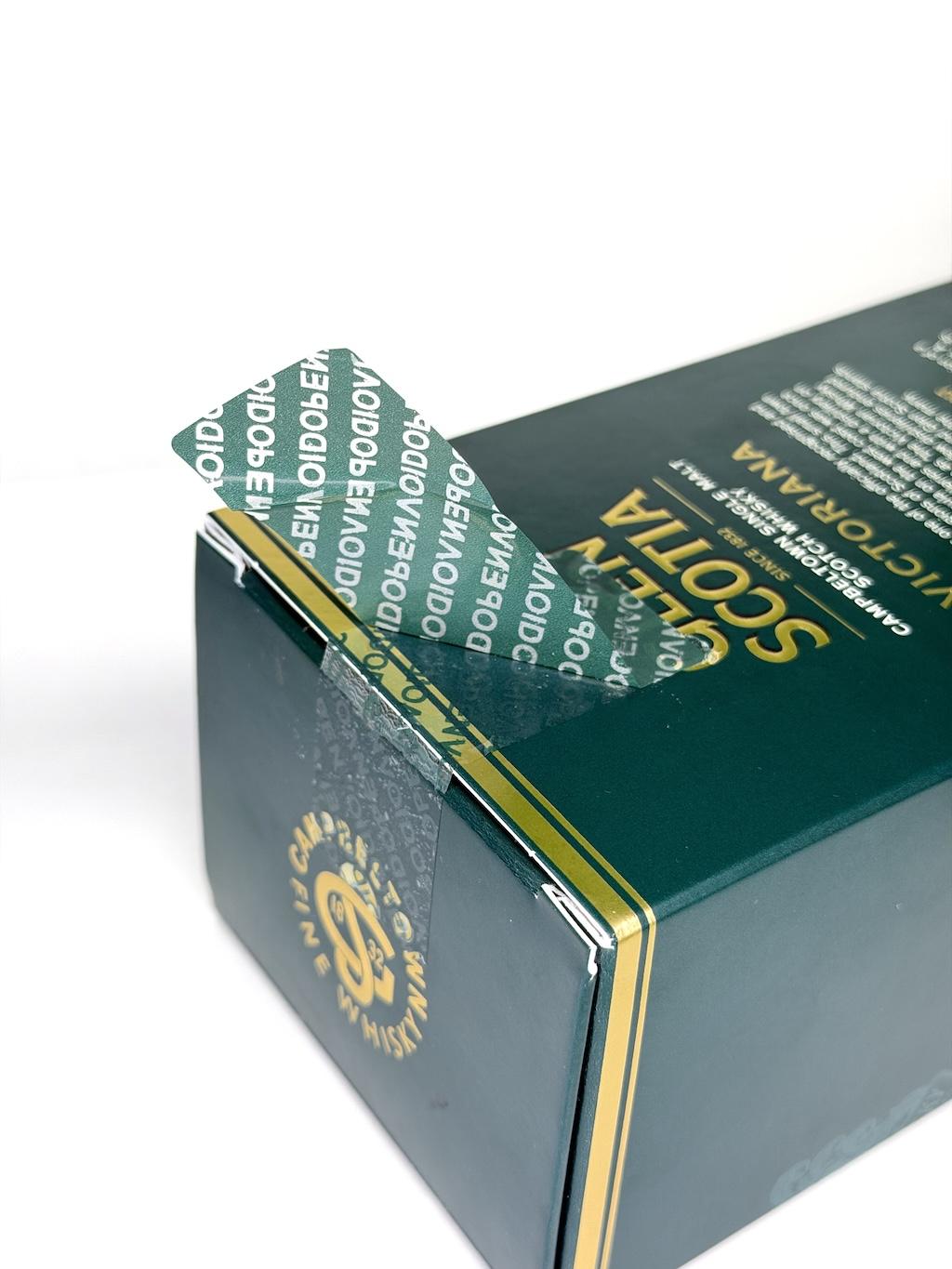 Green whisky bottle showing voided tamper-evident security label after opening for brand protection