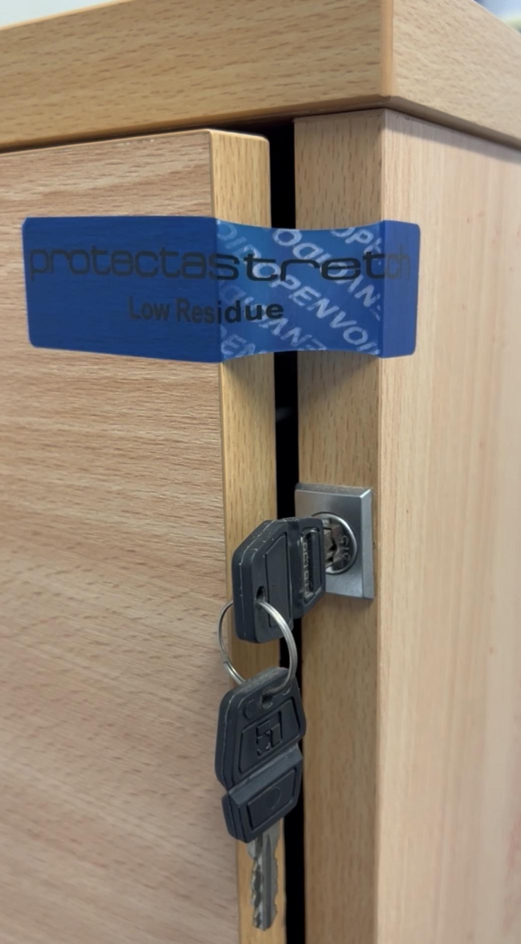 Stretch tamper-evident label applied to a filing cabinet